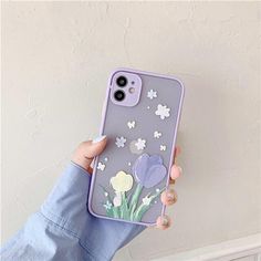 a person holding up a phone case with flowers on the front and back cover in purple