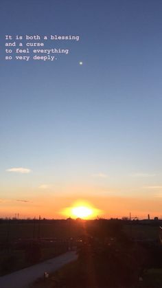 the sun is setting over a rural area