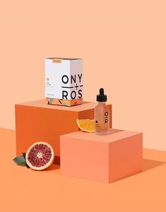 two oranges and one grapefruit sitting on top of boxes