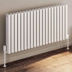 a white radiator sitting on top of a wooden floor