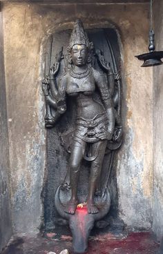 a statue in the corner of a building with blood on the floor and light coming from it