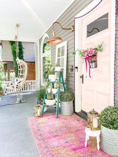 the front porch is decorated with plants and potted plants, including an outdoor hammock