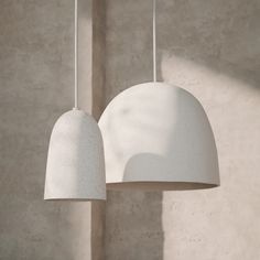 two white lamps hanging from the ceiling next to each other