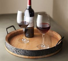 two glasses of wine on a wooden tray