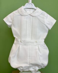 An elegant two-piece set for baby boys to wear during any special occasion. The top has a peter pan collar, geometrical frontal lace, handmade pleats, and short sleeves; it has buttons on the back for closure. The bottom is bubble shorts with buttons on the sides for closure and an elastic band on the back. The interior, or lining, is made with cotton fabric, while the exterior is white organza. Dry clean 2 piece set Interior: 100% cotton; exterior: 100% polyester Made in Spain Final Sale Baptism Outfits For Boys, Bubble Outfit, Heirloom Portraits, Bubble Clothes, Bubble Shorts, Outfits For Boys, Boy Baptism Outfit, Baptism Outfit, Spanish Fashion