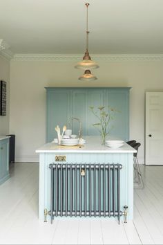 a kitchen with blue cabinets and an island in the middle is featured on instagram