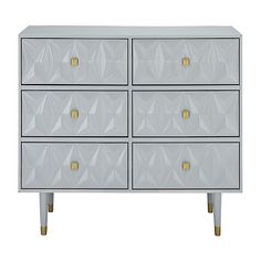 a white dresser with gold handles and drawers