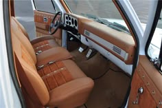 the interior of a car with tan leather seats and brown dash tape on the floor