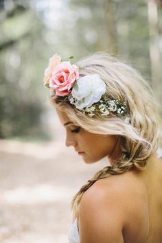 a woman with flowers in her hair wearing a flower headpiece on her wedding day