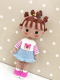 a crocheted doll is standing next to a polka dot wall with a teddy bear on it