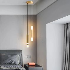 a bedroom with a bed and two lights hanging from the ceiling