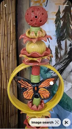 a close up of a bird feeder with a butterfly on it's top and the words image search below