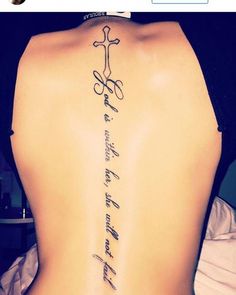 the back of a woman's body with a cross and words on her lower back