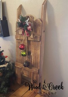 a wooden door with ornaments hanging on it and a christmas tree in the corner next to it