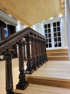 a wooden staircase with metal railing and handrail