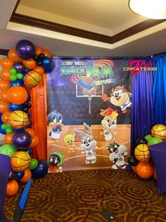 the balloon arch is decorated with cartoon characters and basketballs for a birthday party at disney's all star sports resort