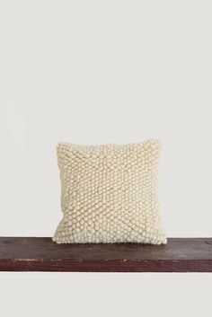 a white pillow sitting on top of a wooden shelf