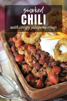 a wooden bowl filled with chili and beans