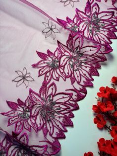 purple and silver lace with red flowers on white background, closeup shot from above