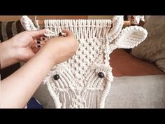 a woman is working on a piece of crocheted material with yarn and beads