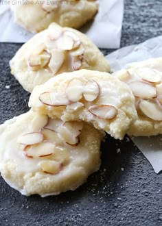 three cookies with almonds on top are sitting on the table next to each other