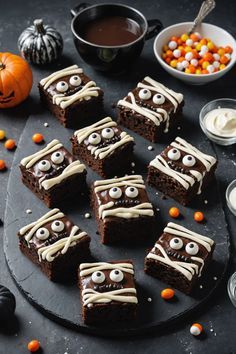 halloween brownies with white frosting and eyes on a black plate next to candy