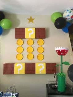 a room decorated with balloons, paper plates and mario birthday decorations on the wall above it