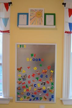 a child's room decorated in yellow, blue and green with pictures on the wall