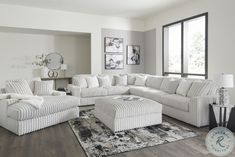 a living room filled with furniture and a large rug on top of a hard wood floor