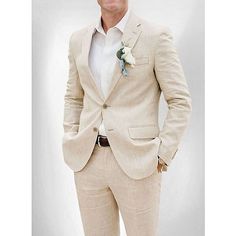 a man in a tan suit and flower boutonniere is posing for the camera