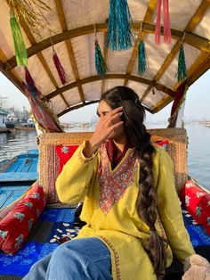 a woman sitting on top of a boat in the water