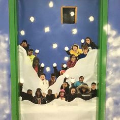 a group of people standing in front of a fake snow covered mountain with lights on it