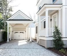 a white house with two garages on each side