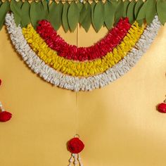 a close up of a decoration made out of flowers and leaves on a yellow background