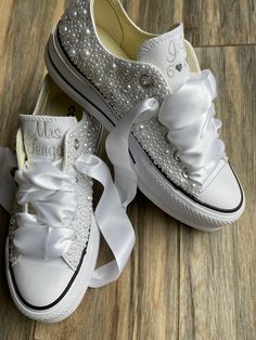 two pairs of white shoes with bows on them