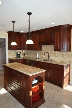 a large kitchen with wooden cabinets and marble counter tops, along with an island in the middle