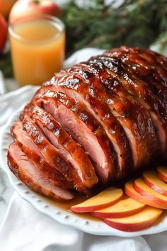 sliced ham on a plate with apples and orange juice