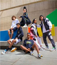 a group of people posing for a photo in front of a building with multicolored background