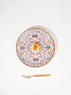 a plate with a fork on top of it next to another plate that has a flower design