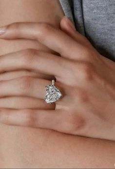 a woman's hand with a diamond ring on it