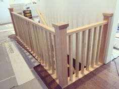 a wooden banister next to a white wall