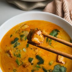 a close up of a bowl of food with chopsticks