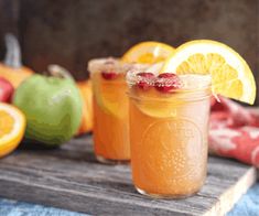 two mason jars filled with orange juice and garnished with pomegranate