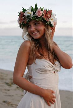 a woman wearing a flower crown on the beach