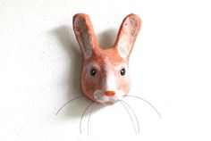 a clay rabbit head mounted on the wall