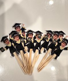 a group of children in graduation caps and gowns on toothpicks with stickers