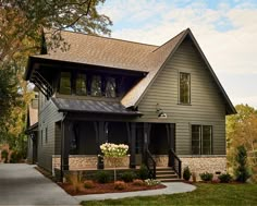 a large house with lots of windows on the front and side of it's roof