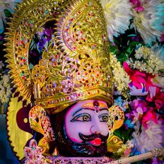 an idol is shown with flowers in the background