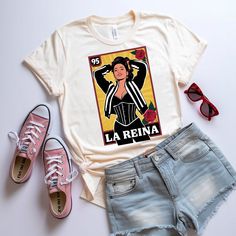 a t - shirt with the words la reina on it next to two pairs of shorts