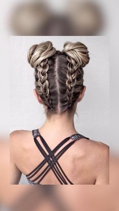 the back of a woman's head with two braids in it